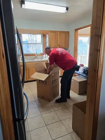 Naglee mover loading boxes in a wood-paneled room